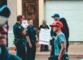 Street protest in Wheeling, WV highlighting immigration issues with signs and police presence.