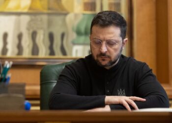 Ukrainian President Volodymyr Zelenskyy sitting at desk.