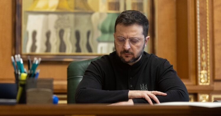 Ukrainian President Volodymyr Zelenskyy sitting at desk.