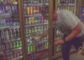 man getting can in beverage cooler