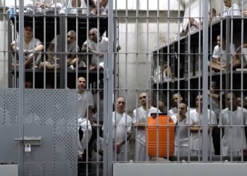 Prisoners standing behind bars in 'World's Worst Prison' CECOT
