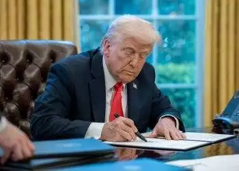 Donald Trump sitting at desk