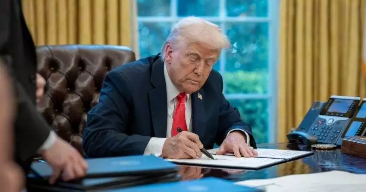 Donald Trump sitting at desk