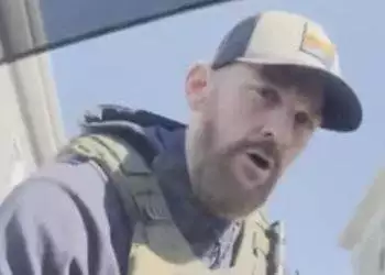 ICE agent detaining man in car