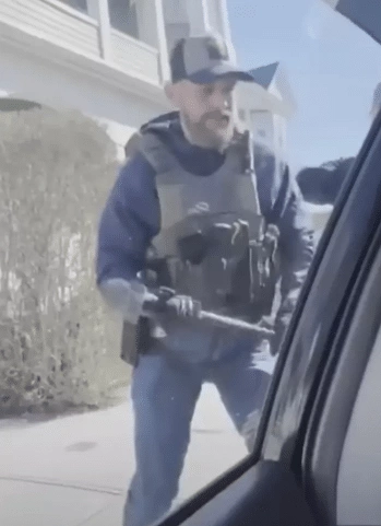 ICE agent using a hammer to break car window