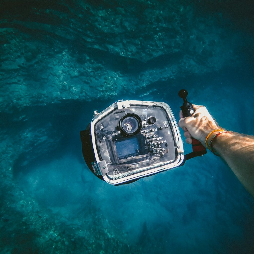 person holding underwater camera