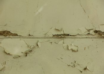 a close up of a wall with peeling paint