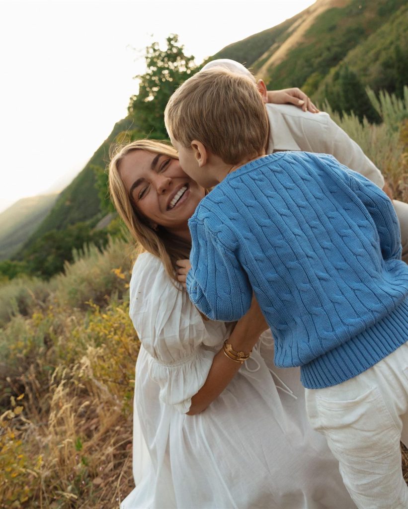Emili Kiser with her husband and their son Trigg with Trigg kissing her on the cheek