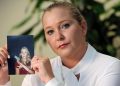 Virginia Giuffre holding a picture of herself when she was younger