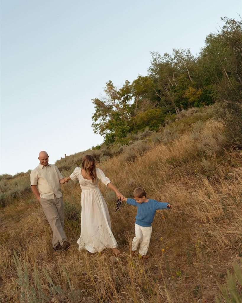 Emili Kiser with her husband and their son Trigg in a field