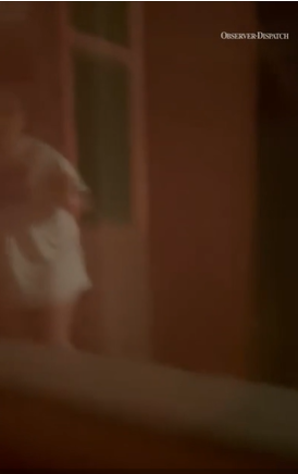 Girl in house attached to burning garage appearing at the door