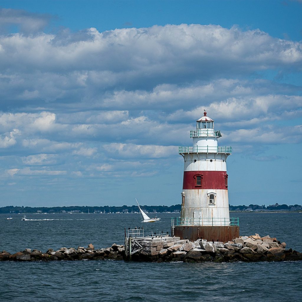 a red and white lighthouse sitting on top of a pier