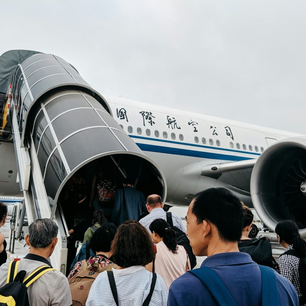 people walking towards airplane during daytime