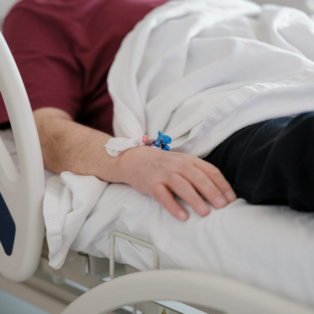 a man laying in a hospital bed with a cast on his arm