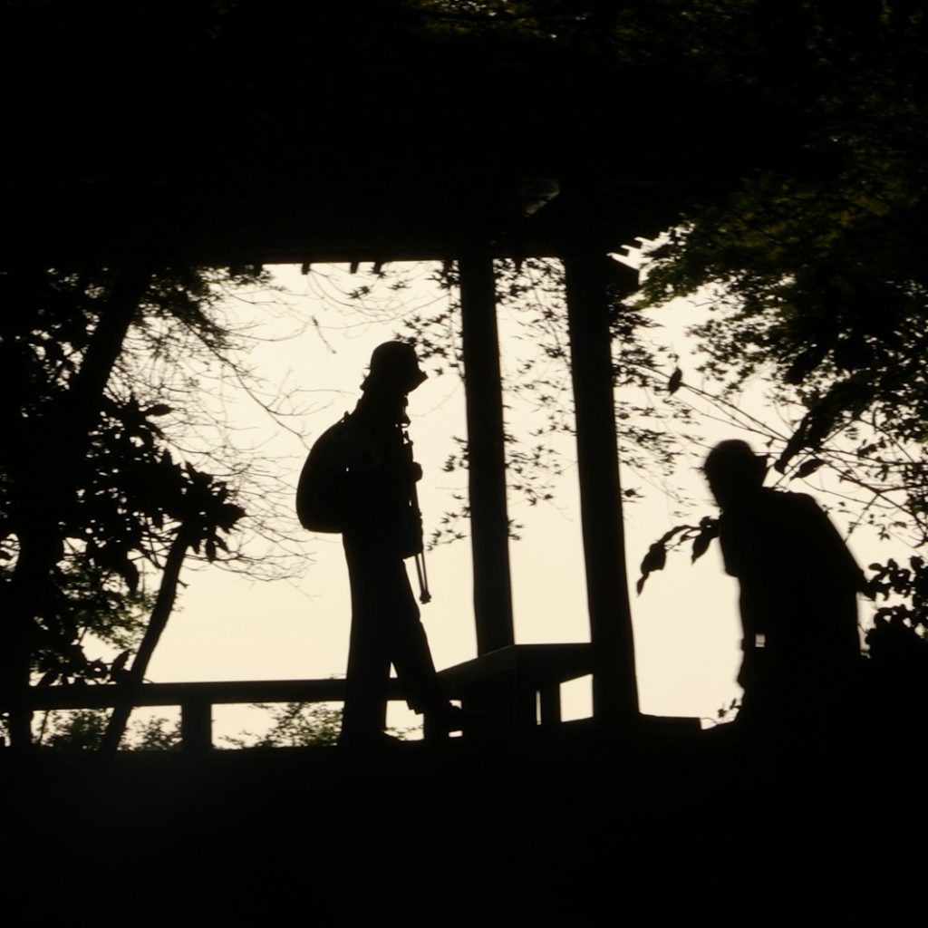 A couple of people that are standing in the dark
