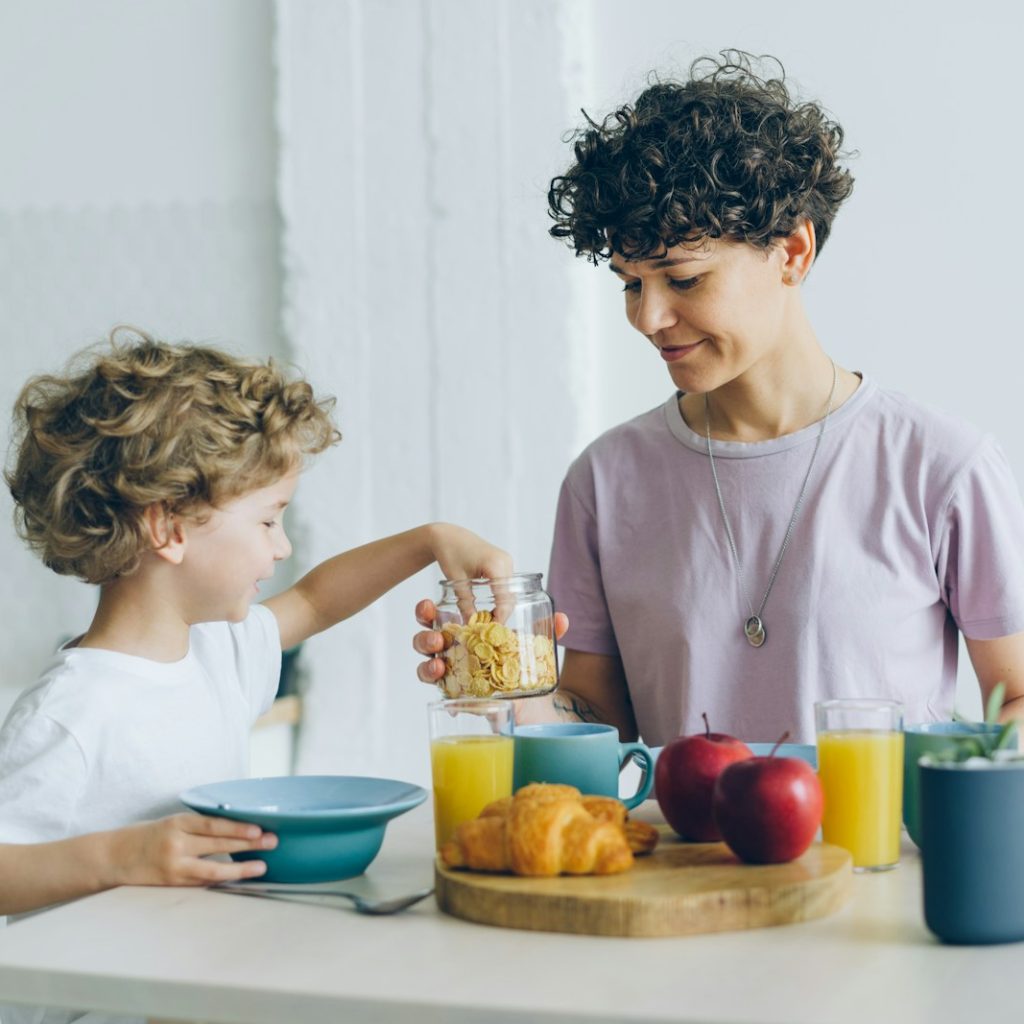 a woman and a child are having breakfast together