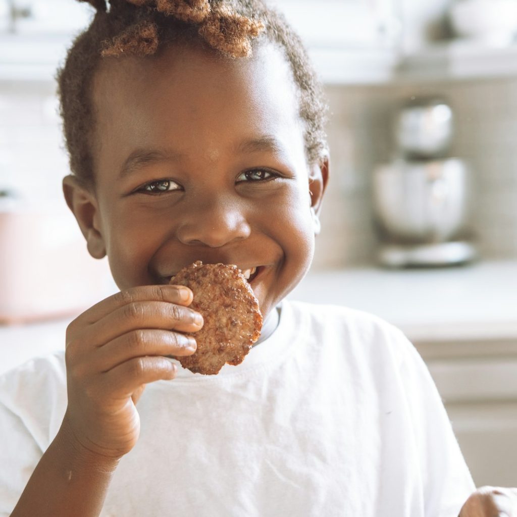 girl in white shirt holding brown bread