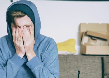Man sitting with both hands on his face