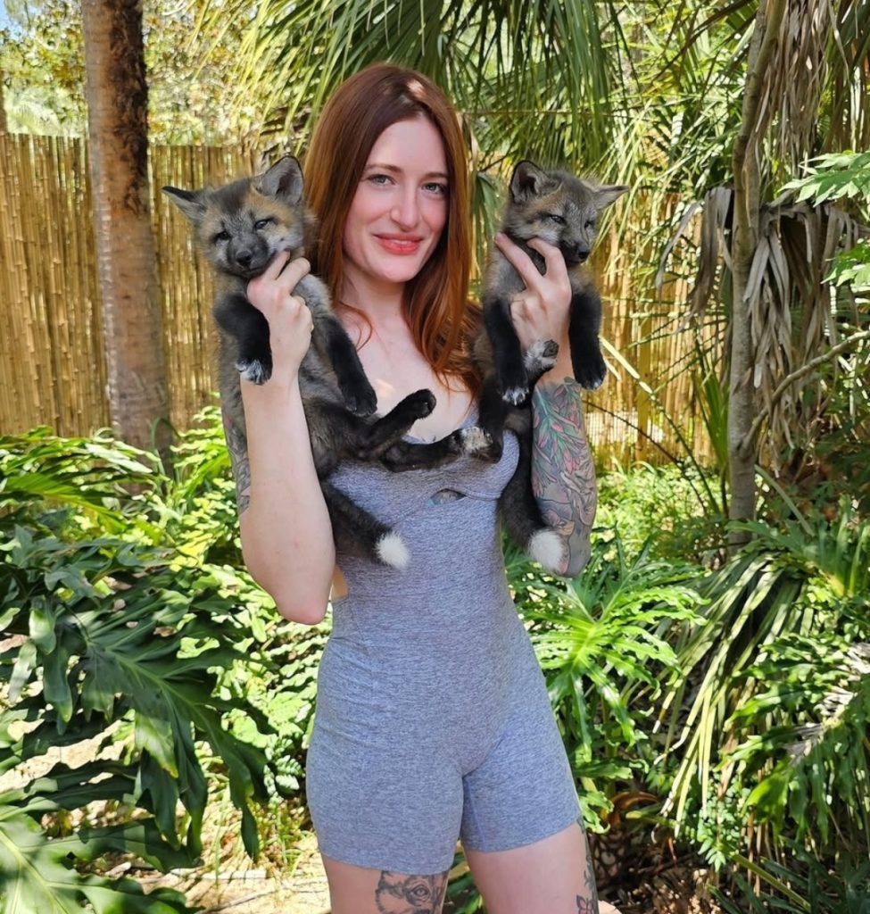 Mikayla Raines holding two foxes