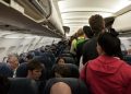 People standing in plane isle