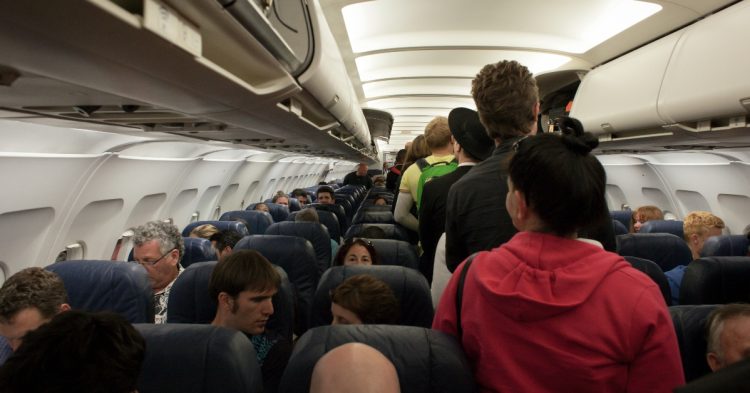People standing in plane isle