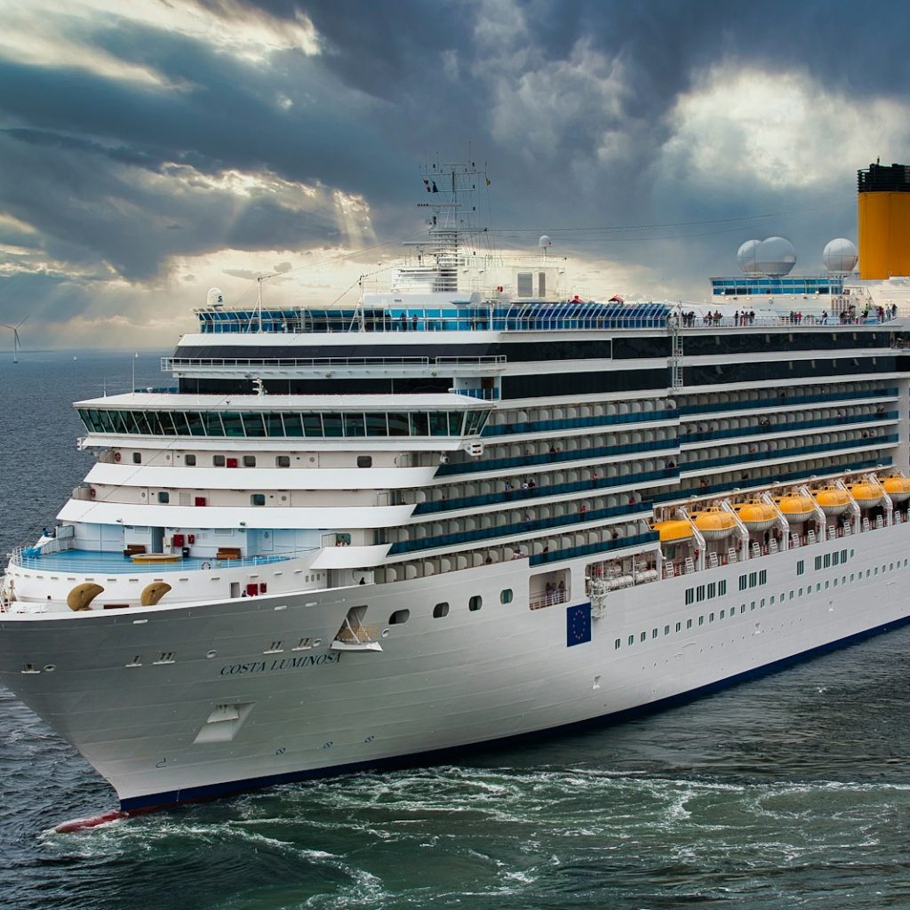 white cruise ship on sea under white clouds and blue sky during daytime