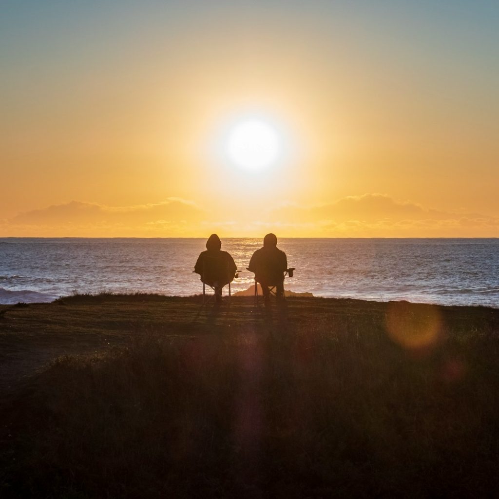 two people sitting on seashore