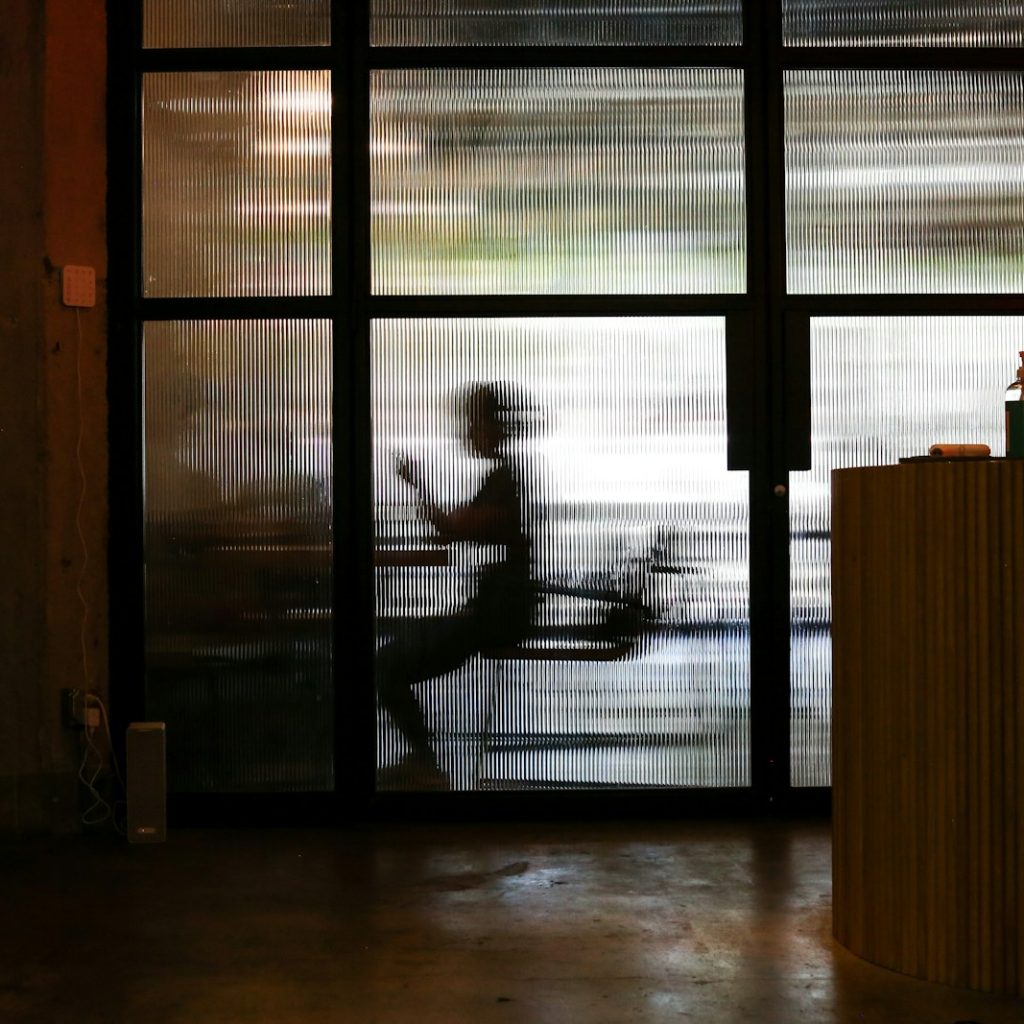 man in white t-shirt standing near window