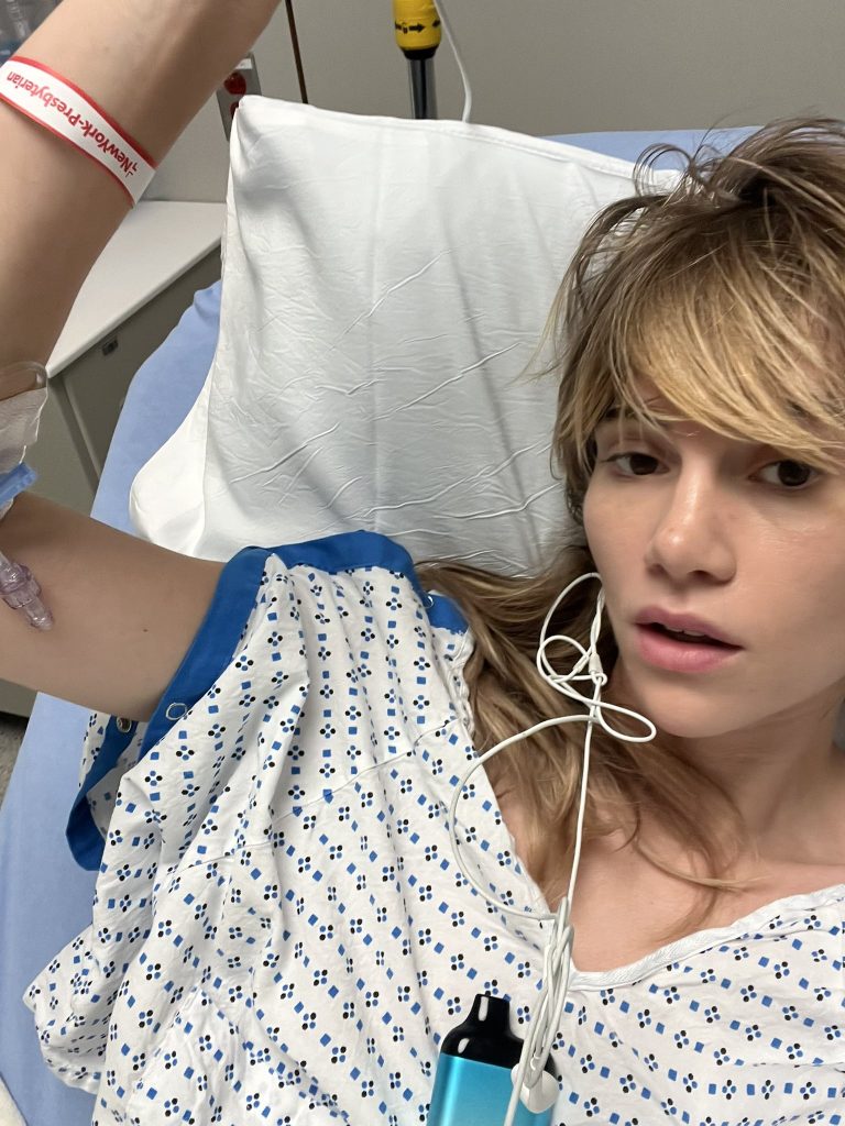 Suki Waterhouse laying in hospital bed