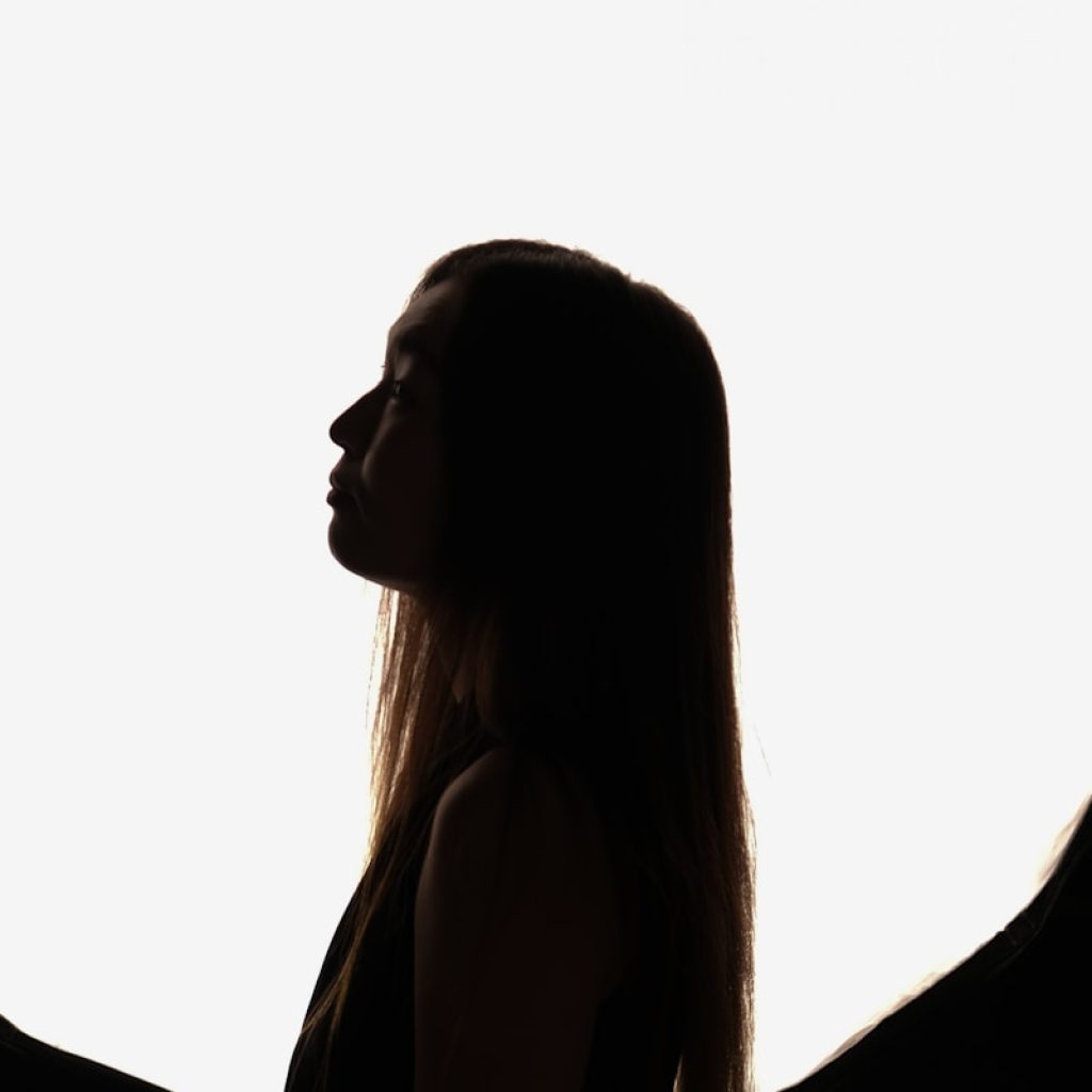 a woman with long hair standing in front of a white background
