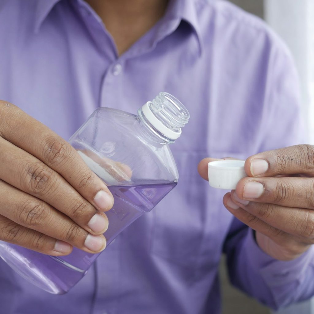person holding white plastic bottle