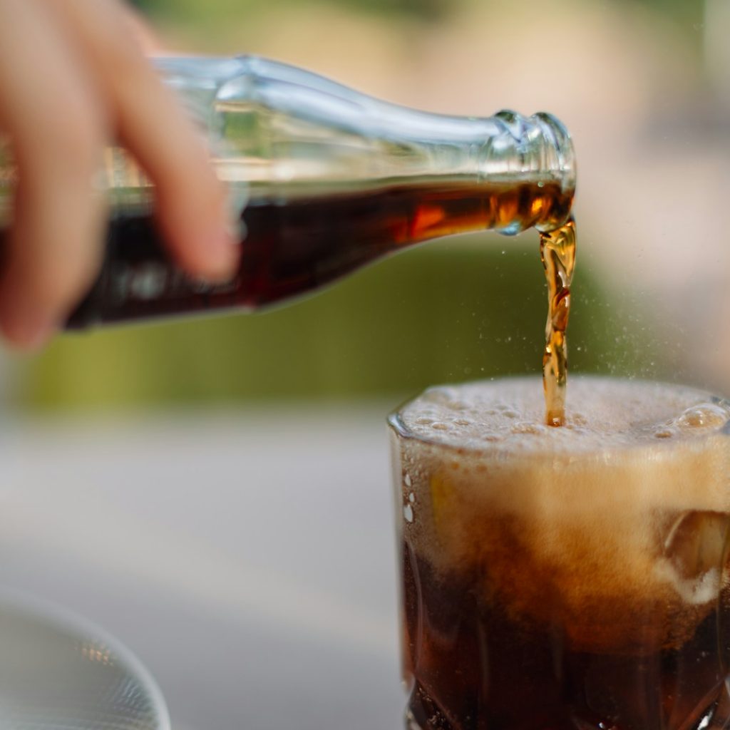a person pouring a beverage into a glass