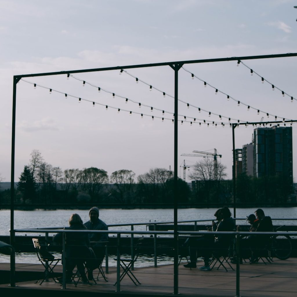 a group of people sitting on a bench by a body of water
